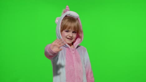 Little-child-girl-smiling,-waving-greeting,-hello-or-bye-with-hand-in-unicorn-pajamas-on-chroma-key