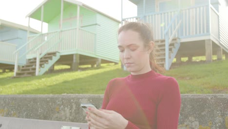 una joven se sienta a disfrutar de su entorno y apaga el destello de la lente de su teléfono.