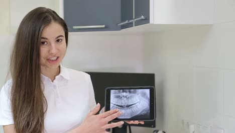 dentist showing panoramic x-ray on tablet