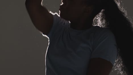 backlit head and shoulders studio portrait shot of young woman dancing in spotlight 6