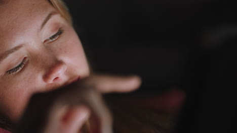 hermosa adolescente usando una tableta viendo entretenimiento por la noche navegando en línea disfrutando de una noche relajante