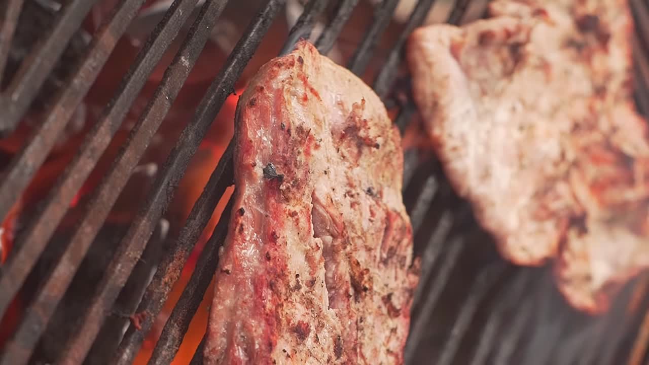 video vertical de carne asada a fuego abierto con llamas lamiendo