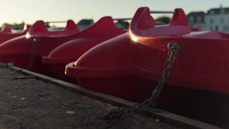 red paddle boats sit empty as evening closes in