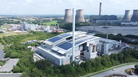 Clean-solar-rooftop-installation-on-modern-office-building-aerial-view-with-coal-power-station-in-background-slow-reverse-shot