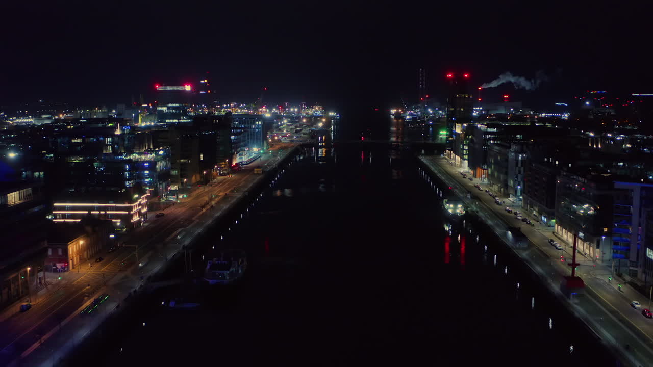 리피 강 위에서 촬영된 공중 리버스 돌리, 밤에는 시내 조명과 함께 조용한 더블린을 보여줍니다.