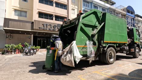 trabajadores cargando basura en un camión de basura