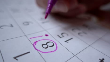 un hombre hace un sello de fecha en el calendario. planear unas vacaciones. cumpleaños. cerca. comercializar la fecha en el calendario, cerca.