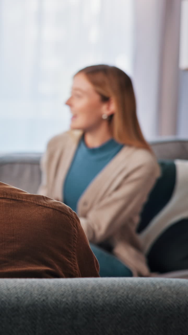 Mand, der sidder på sofa bagfra under samtale