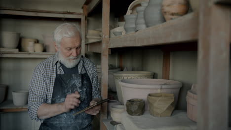senior potter taking notes in a workshop