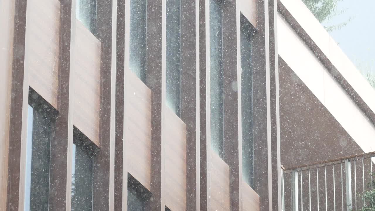 современное здание с дождем, падающим на него