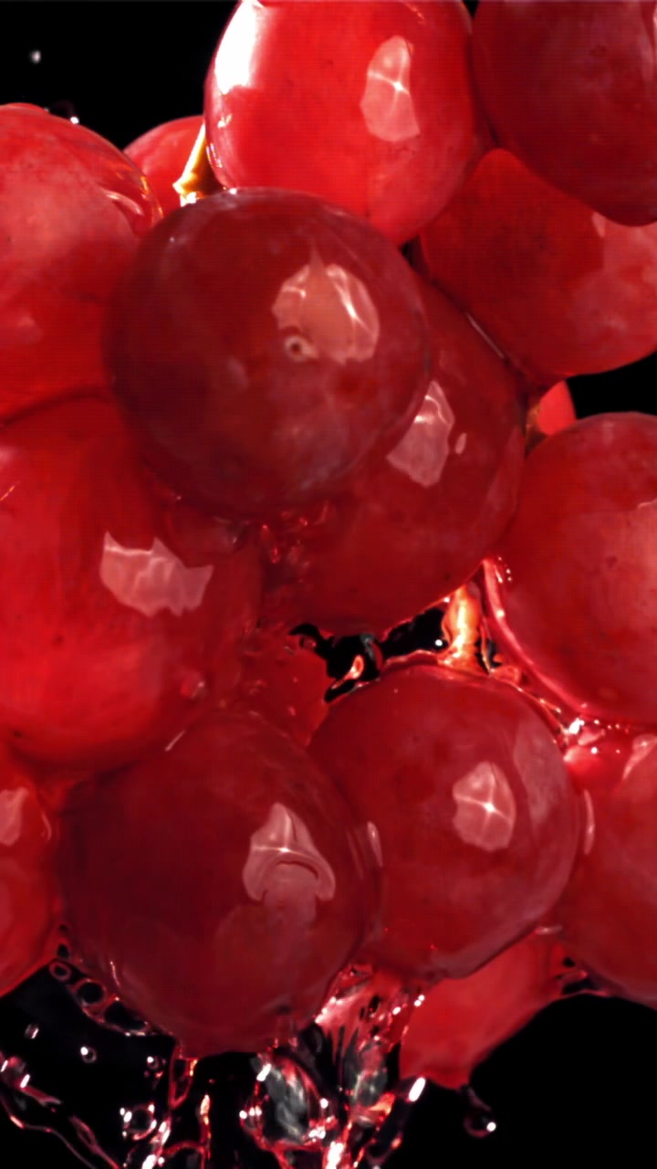Fresh Red Grapes Splashing with Water in Slow Motion