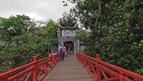 visitantes caminando sobre un puente rojo tradicional