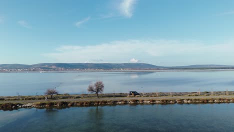 aerial tracking shot of a van driving along a highway over a lake in france
