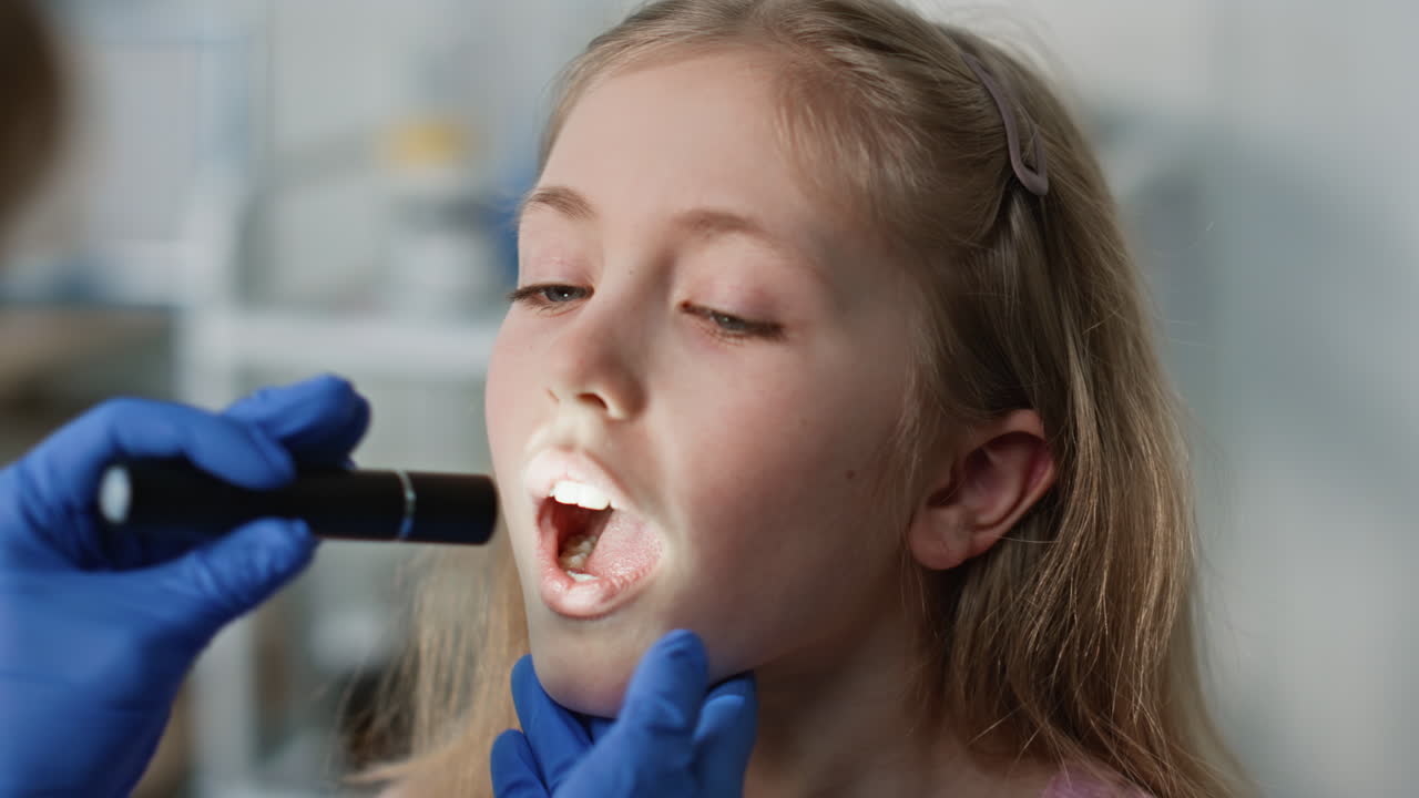 Girl patient opening mouth for throat examination closeup. Cute child visiting
