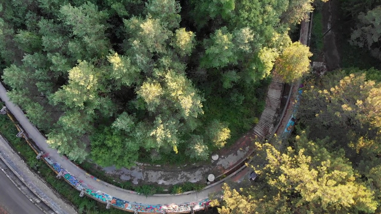 Aerial: Sarajevo Olympic Bobsleigh track in Trebević mountain. Zenital shot. Drone going down