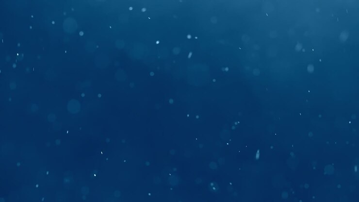partículas blancas ascendentes contra un fondo azul