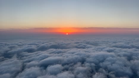 fire sunset shot from an airplane cockpit while flying over the a layer of stratus clouds