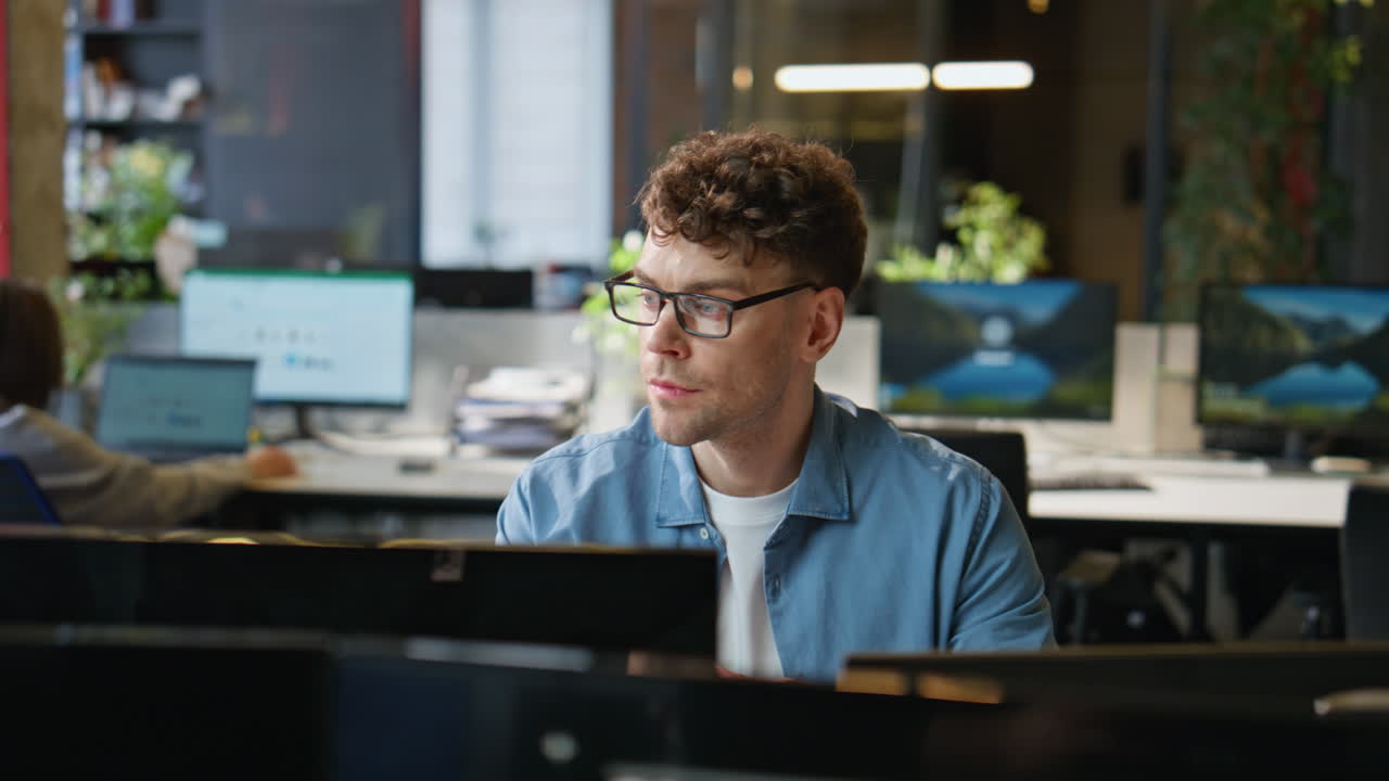 Serious man looking monitor at corporate office closeup. Guy employee working