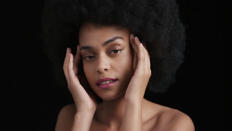 Porträt-Einer-Attraktiven-Afroamerikanischen-Frau,-Die-Ihr-Gesicht-Mit-Den-Händen-Berührt,-Einen-Glatten,-Gesunden-Teint-Streichelt-Und-Die-Perfekte-Natürliche-Schönheit-Genießt,-Funky-Afro-Auf-Schwarzem-Hintergrund