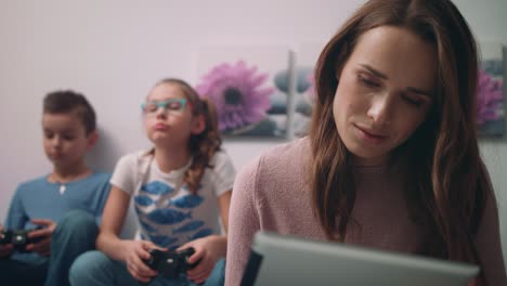 madre trabajando en una tableta pc. mujer freelance trabajando en casa