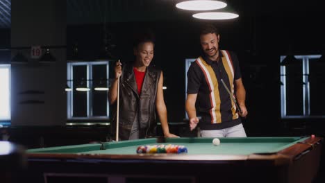 couple playing pool at night