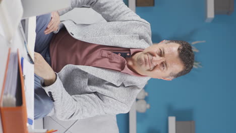 Vertical-video-of-Home-office-worker-old-man-making-negative-gesture-at-camera.