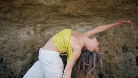 flexible girl practicing contemporary choreography in front sandy rock close up