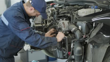 mechanic repairing car engine in auto workshop