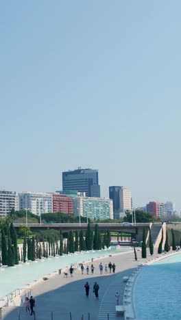 Cityscape with people walking by a modern fountain and buildings