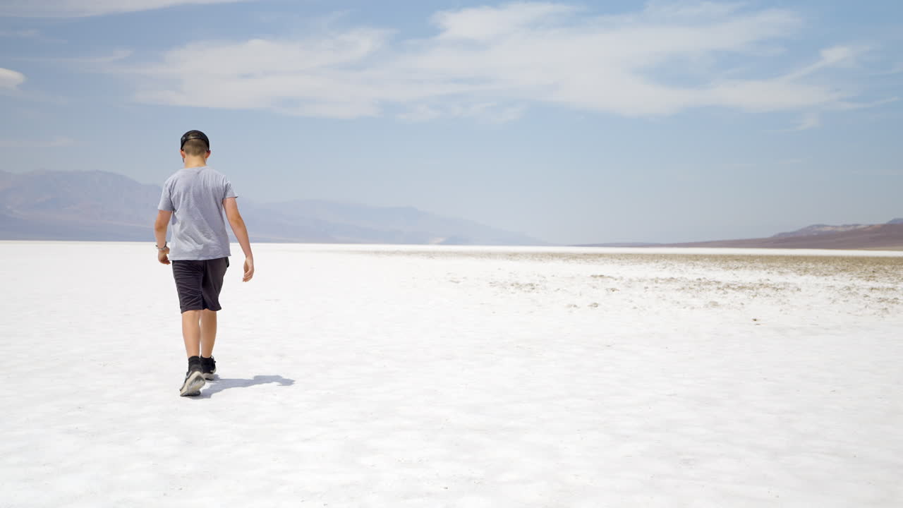 Boy walking in a vast desert salt flat