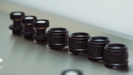 showcasing seven black lenses for an army scope laid side by side