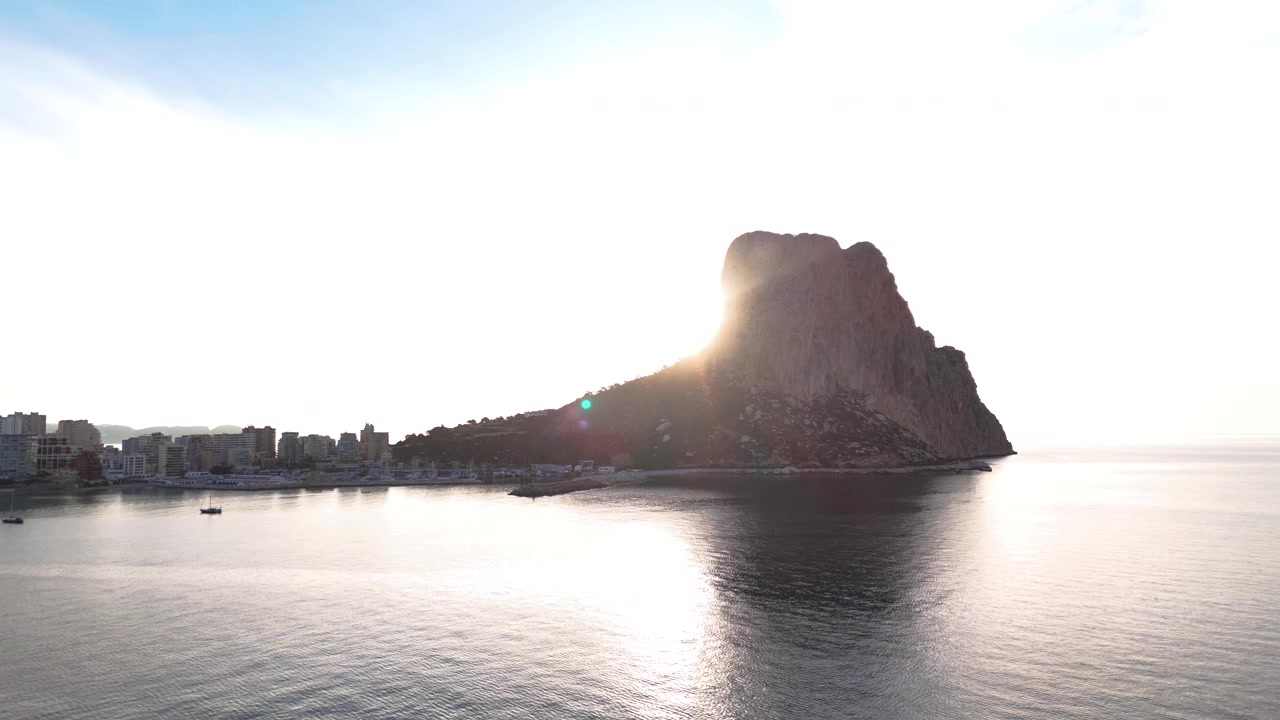 Caratteristica roccia costiera panoramica a Calpe, Spagna, con mare calmo e barche nelle vicinanze.