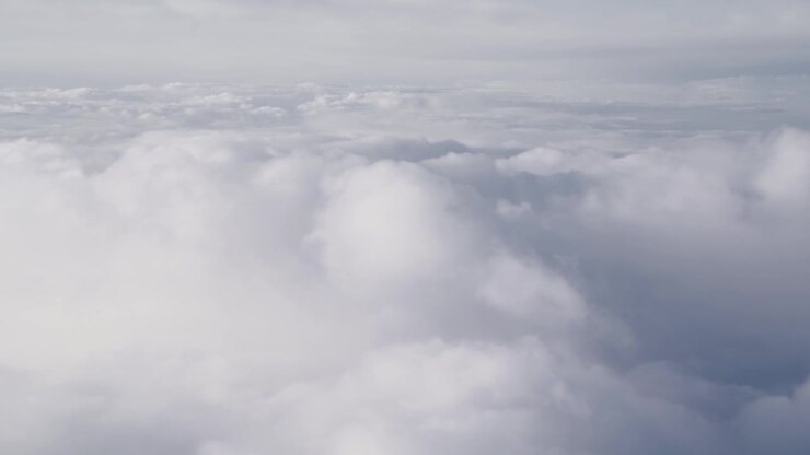 Flying above a grey clouds, high density cloudy sky, from a plane. Location western Europe, summer time