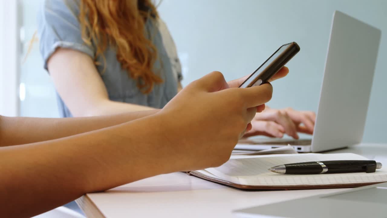 ejecutivos que usan teléfonos móviles y computadoras portátiles en la oficina 4k