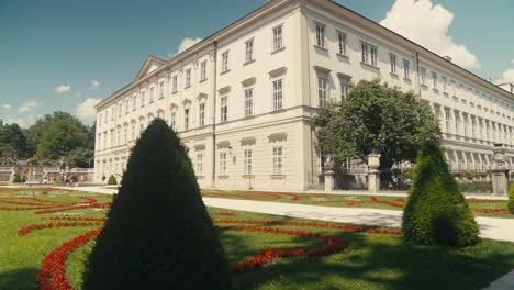 Sunrise-over-Schloss-Mirabell-with-blooming-flowers-and-the-Hohensalzburg-Fortress-in-the-distance,-clear-sky