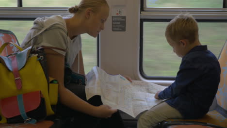 mother and child with map traveling by train