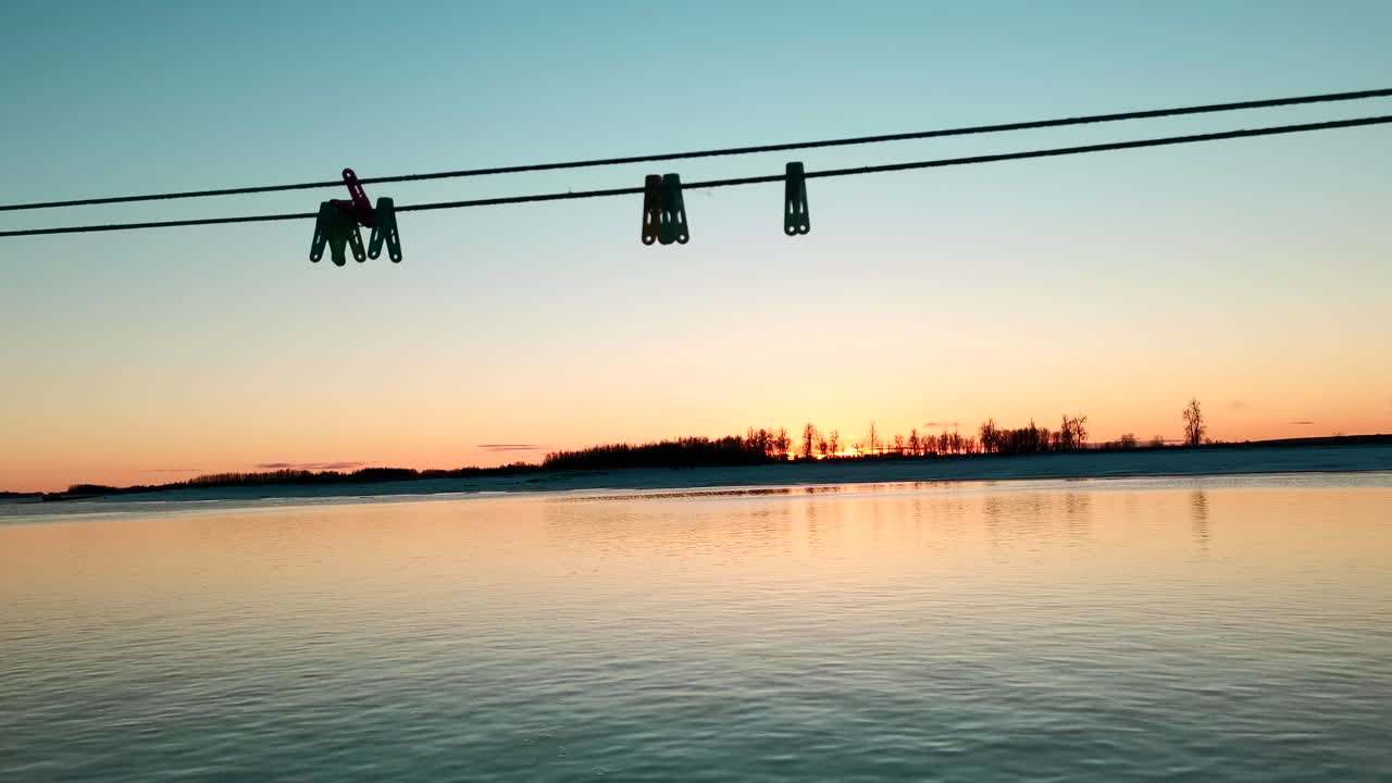 옷줄로 얼어붙은 강을 가로질러 해가 뜨는 것