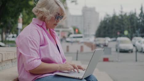 mujer trabajando en una computadora portátil al aire libre