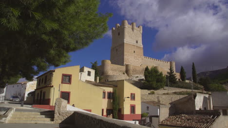 Vista-De-ángulo-Bajo-Del-Castillo-De-Atalaya-Haciendo-Una-Vista-Increíble-Con-Nubes-Moviéndose-Bajo-El-Cielo-Azul,-Villena,-Provincia-De-Alicante,-Sur-De-España