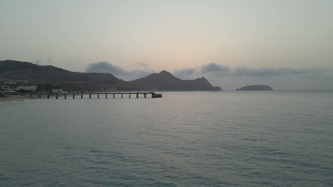 드론은 구름이 낮게 걸려 있는 시원한 회색 아침에 보드워크 지점을 향해 날아간다