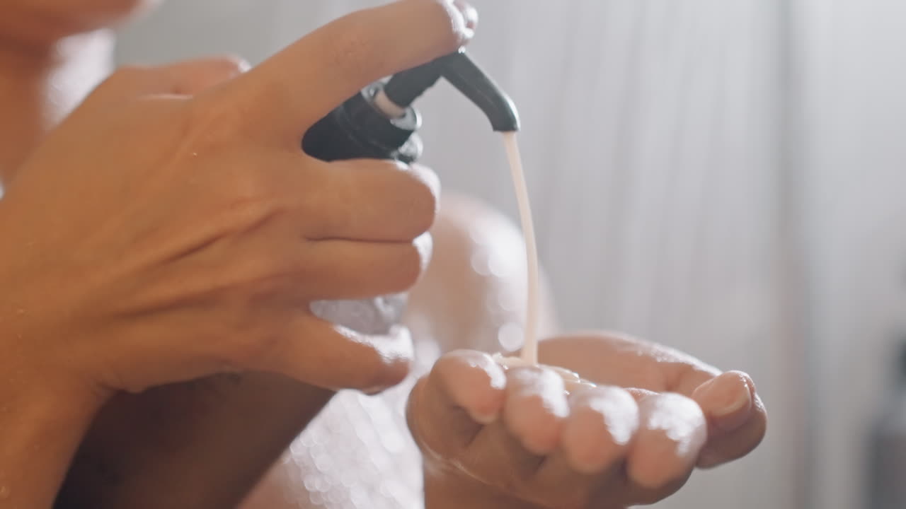 Primo piano di sapone erogato delicatamente. L'illuminazione calda evidenzia un'intima esperienza nel bagno per gli ospiti. Scatto dettagliato del sapone che scende nei palmi con illuminazione soffusa per un'atmosfera accogliente.
