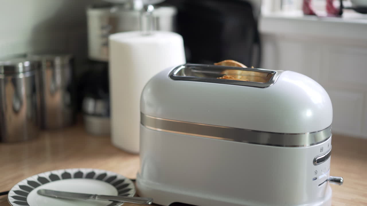 Toasted bagel slowly rising from a quality white toaster, kitchen background with natural light