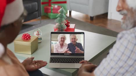 Happy-african-american-senior-couple-on-video-call-with-sdenior-friends-at-christmas