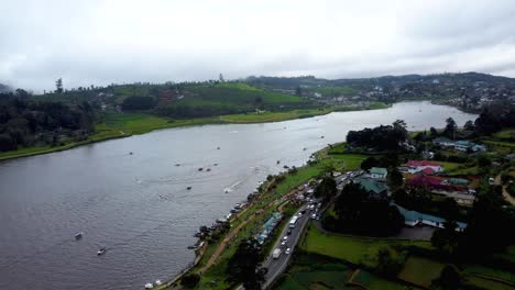 Drone-Aéreo-Sobre-El-Lago-Gregory-Con-Botes-Y-Campo-Verde-En-Un-Día-Nublado-En-Nuwara-Eliya-Sri-Lanka