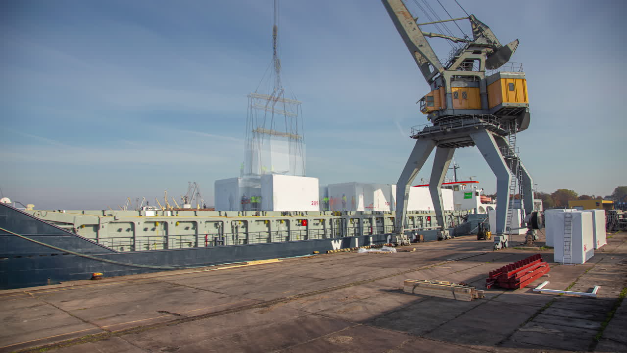 낮 시간에 항구에 정박한 산업 화물선에 고정된 컨테이너를 적재하는 크레인의 시간 경과
