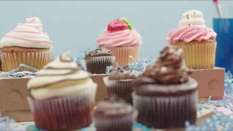 hero shot of a group of fancy decorated cupcakes on a pastel background