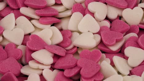 pile of small heart shaped red and white candies rotating.