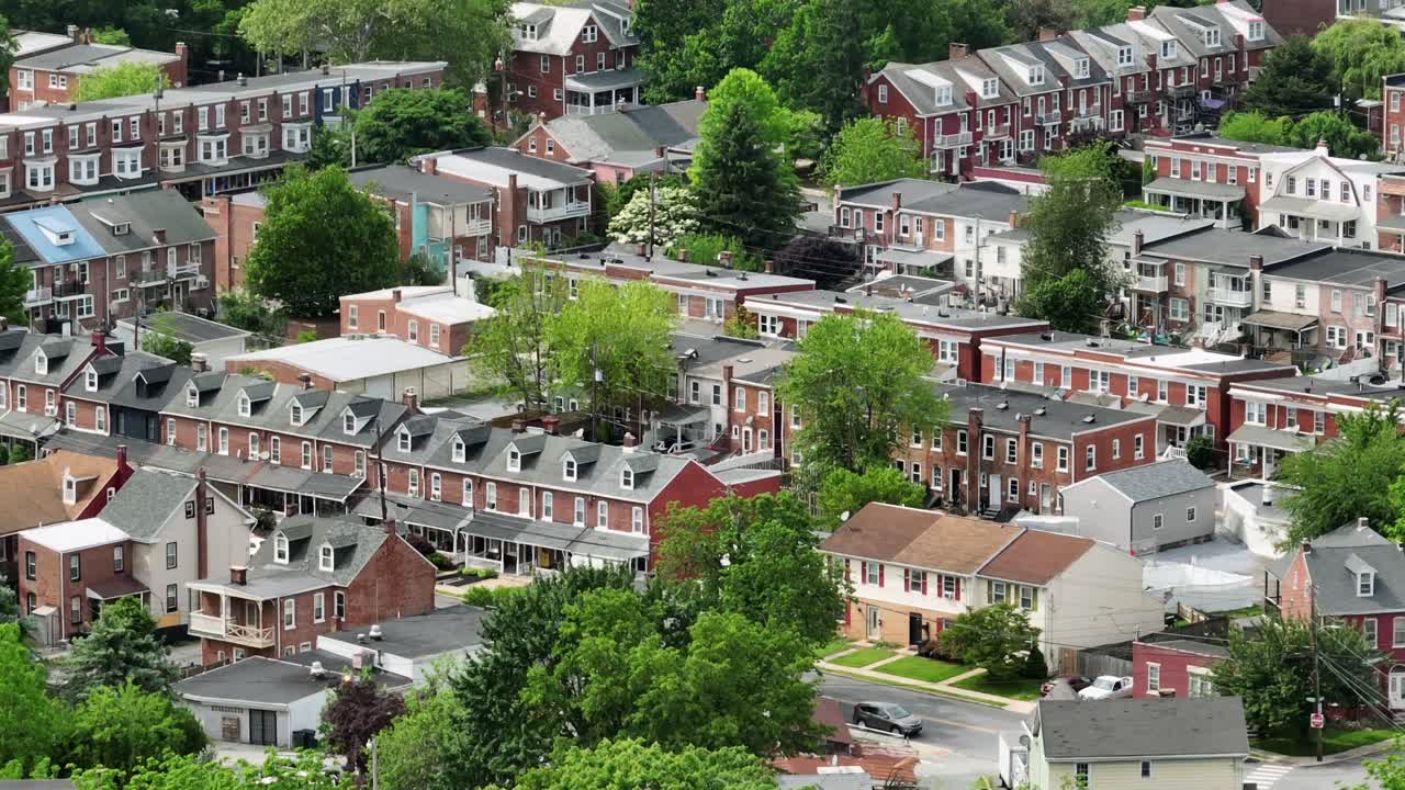 Row of houses in american town during sunny day with green trees. Aerial backwards shot. American classical townhouses in Lancaster City, Pennsylvania.