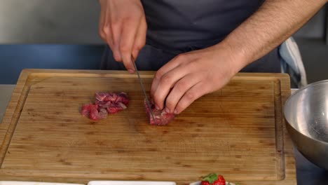 A-chef-cutting-a-piece-of-meat-to-fine-pieces