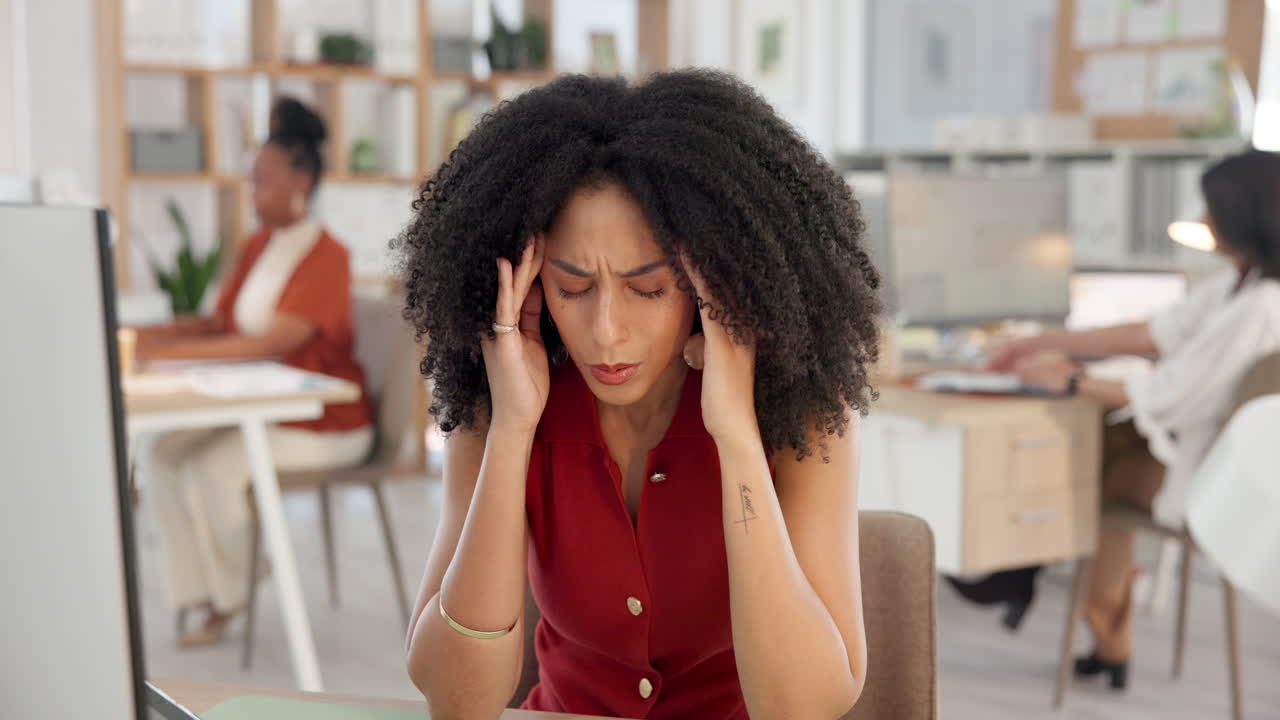 Stressed Businesswoman Suffering from Headache in Office